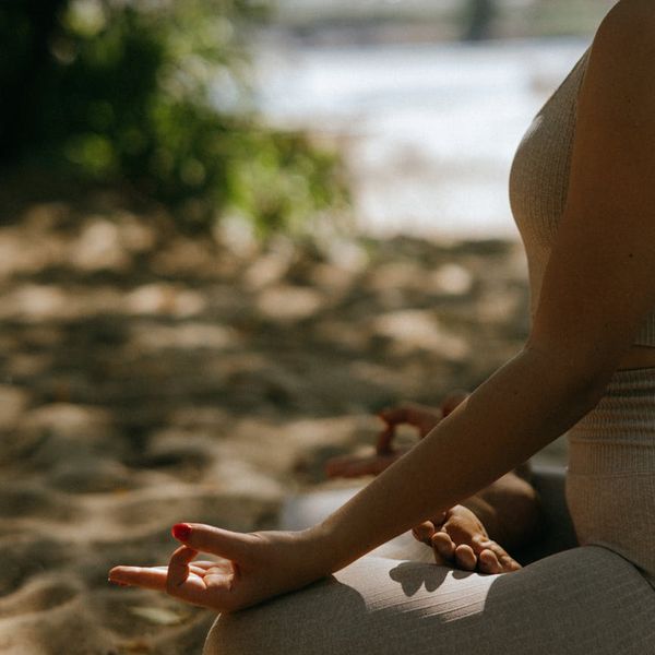 Woman meditating peacefully in a bright, serene environment.